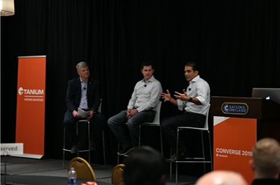「Converge 2025 」カンファレンスのステージで講演する3人の男性