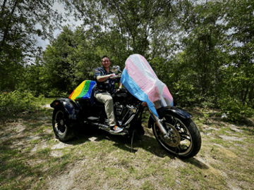 色鮮やかな布をなびかせながらバイクに乗っている人