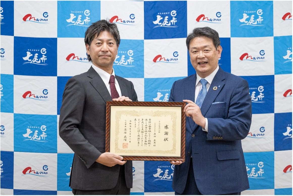 Two men holding framed certificate from city mayor at news event