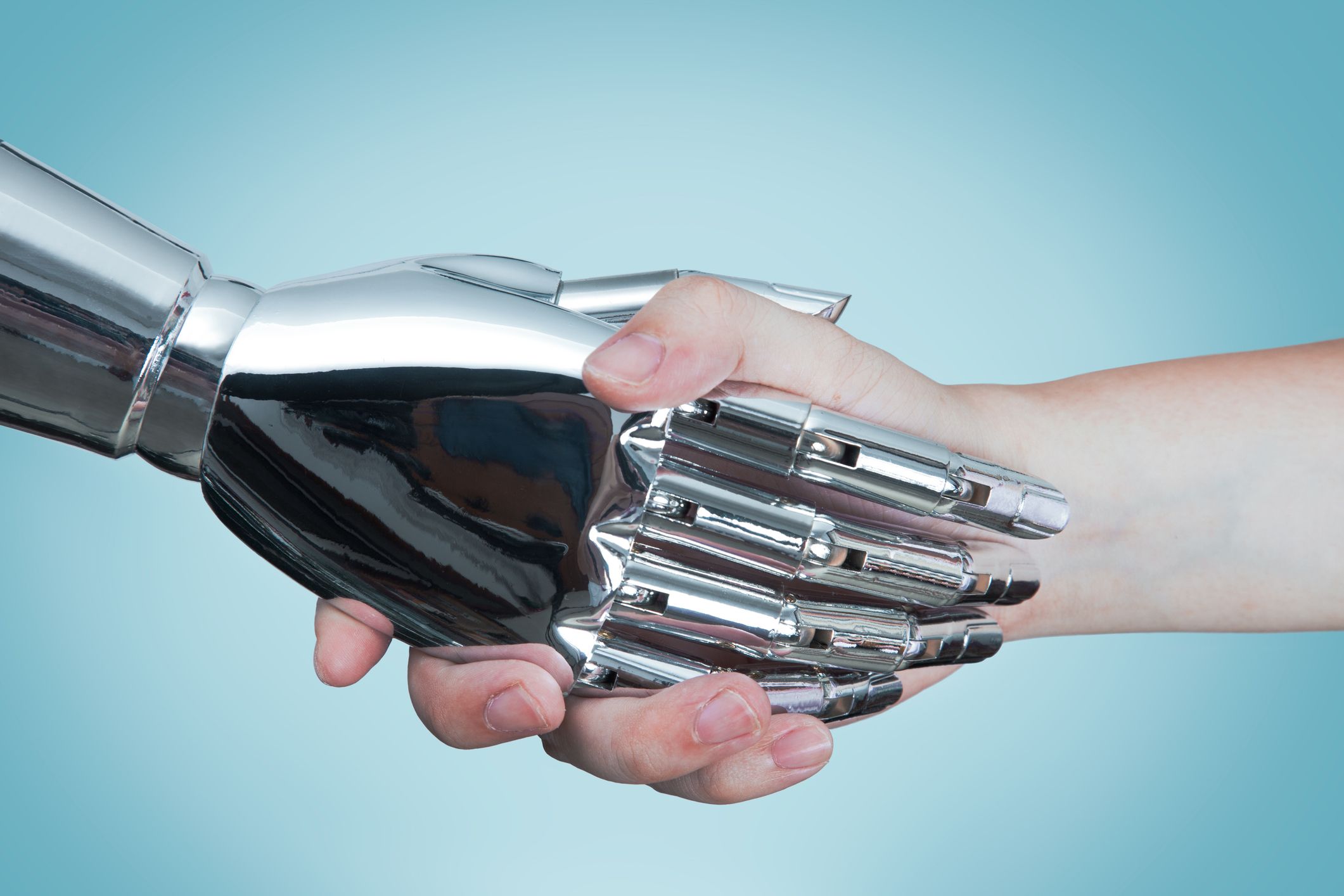 AIロボットと人間が握手している様子を捉えたクローズアップ写真です。