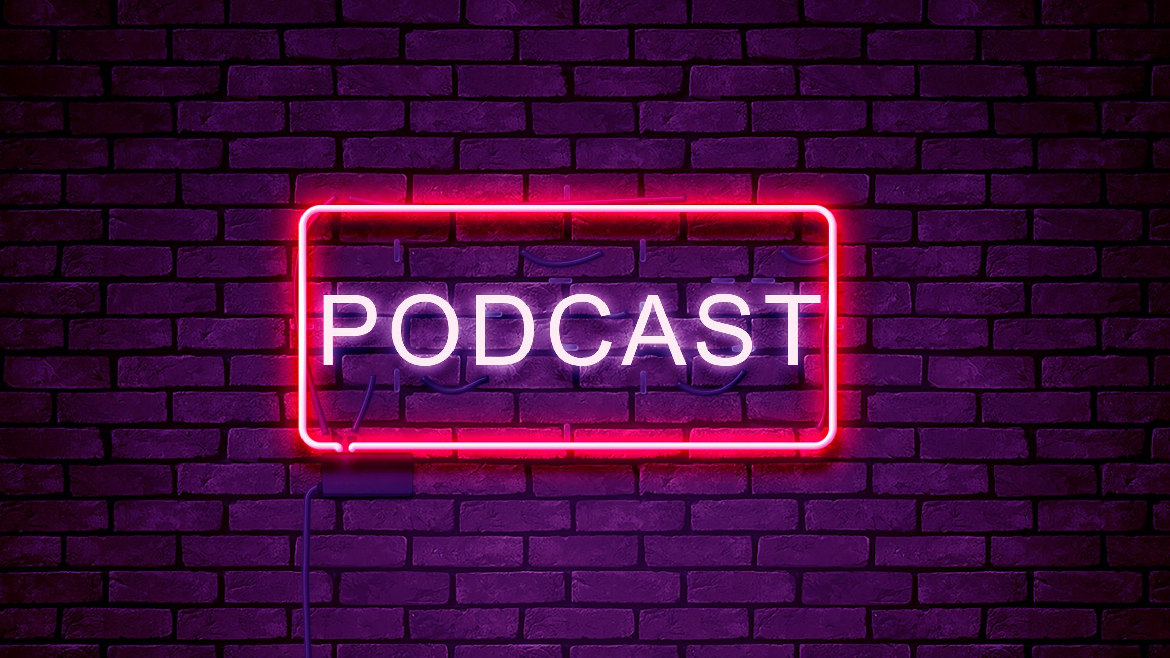 レンガの壁に「podcast」と書かれたネオンサインの写真。