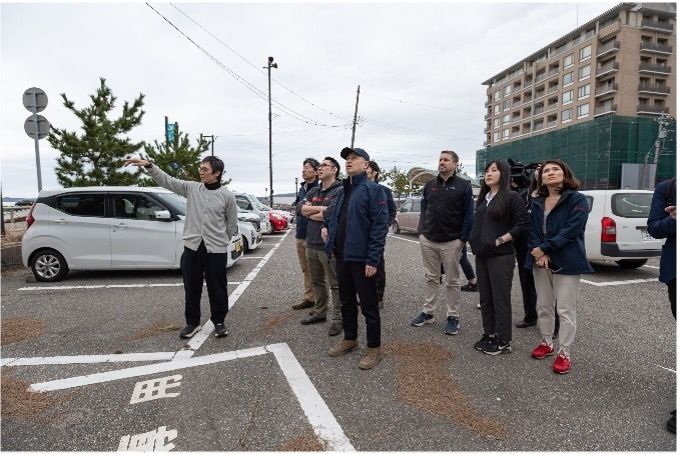 Group of people gathered at parking lot near residential apartment buildings