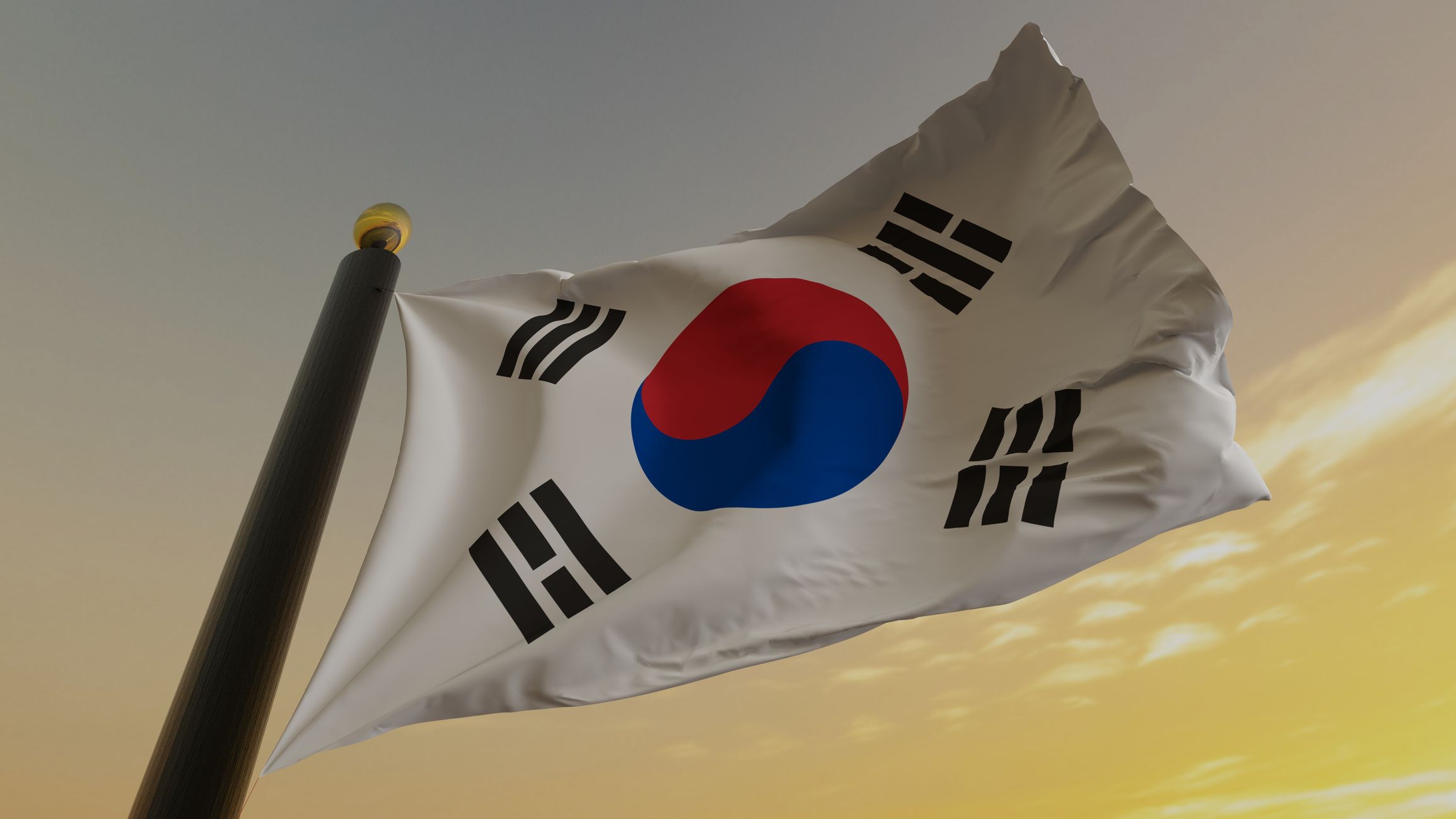 韓国の国旗が風にはためいている。 白地に赤と青の渦巻く円が描かれ、その周囲を三本の黒線からなる記号である四つの卦が囲んでいる。