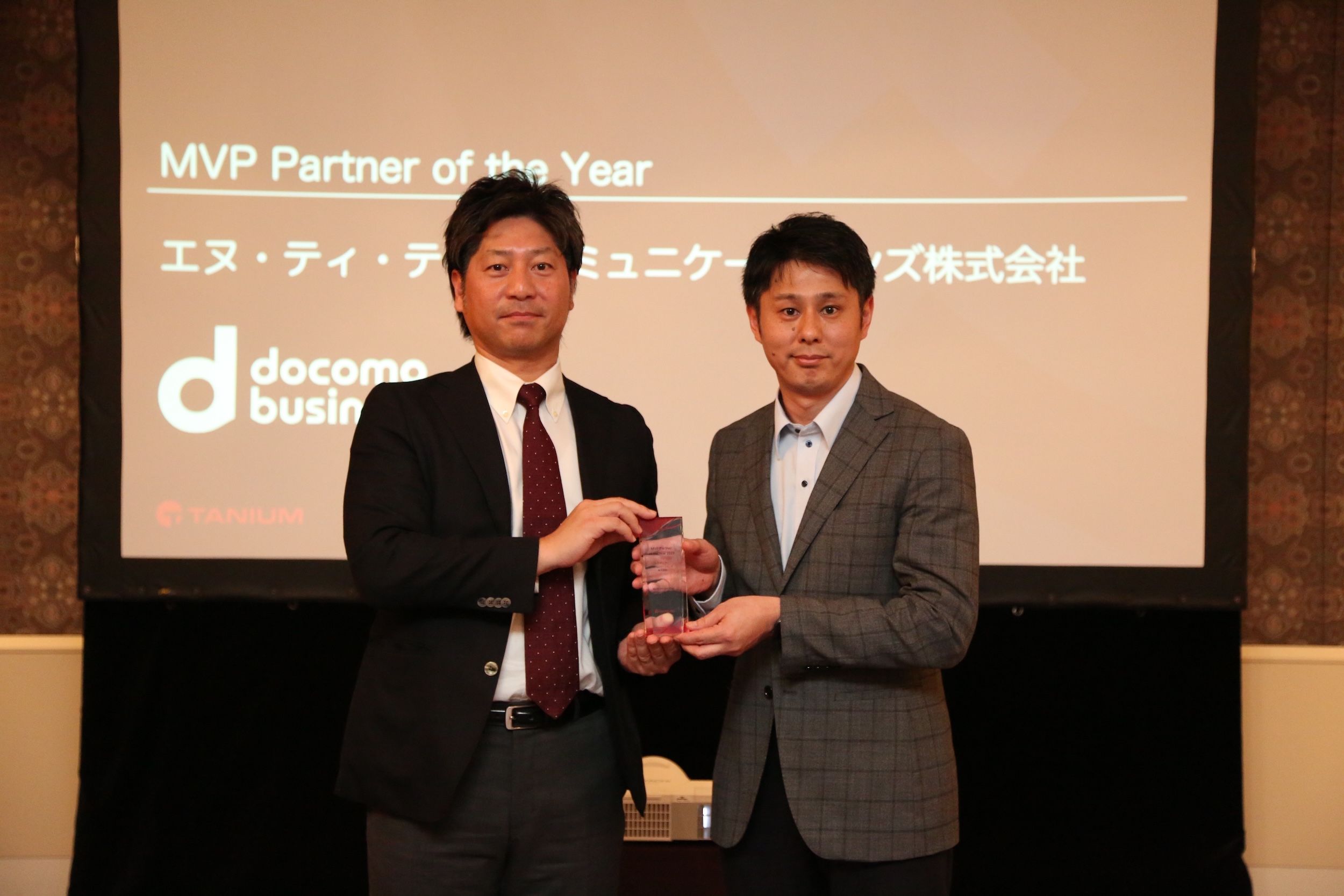 Two executives accepting MVP Partner of the Year award at Tanium ceremony